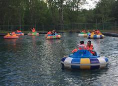 A group of people in water on floats.