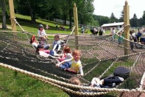 Childrens having fun playing on a playground and lying on their backs on a giant net or hammock