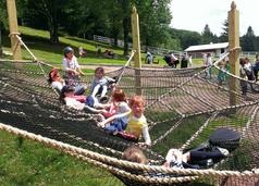 Childrens having fun playing on a playground and lying on their backs on a giant net or hammock