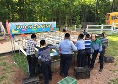 A group of people standing around a duck race.