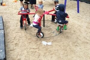 Small kids are turning on the carousel on the playground