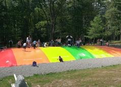 A group of people on the ground near some trees.