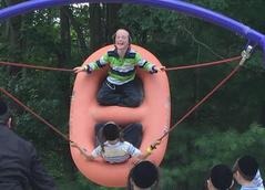 A man riding on top of an orange raft.