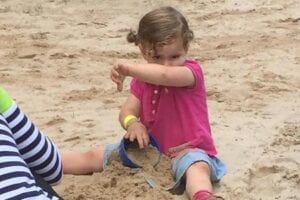 Little girl playing in a sandbox