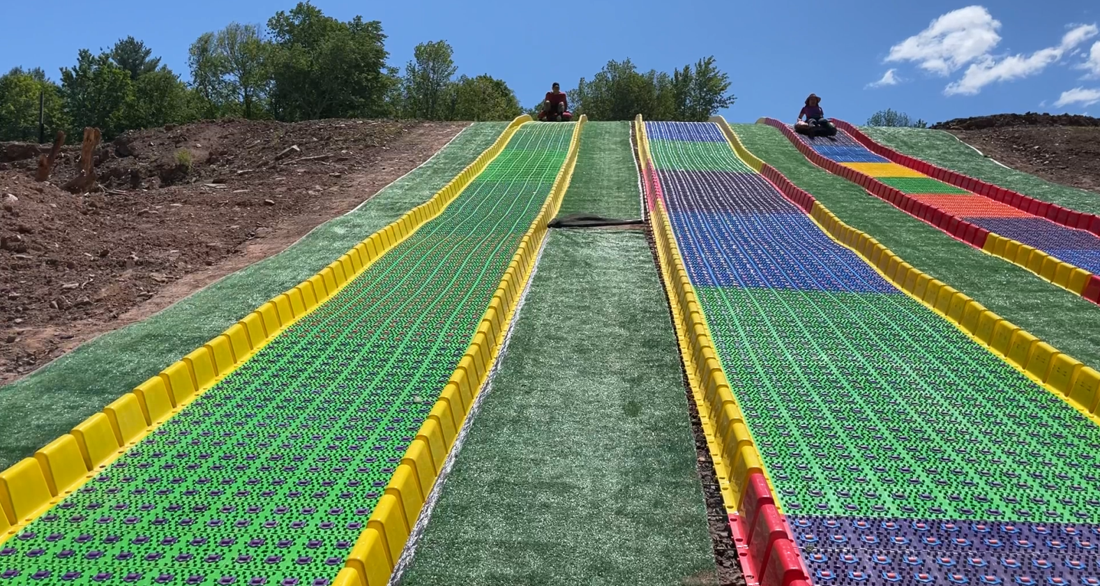 A slope with colored plastic mats and grass.