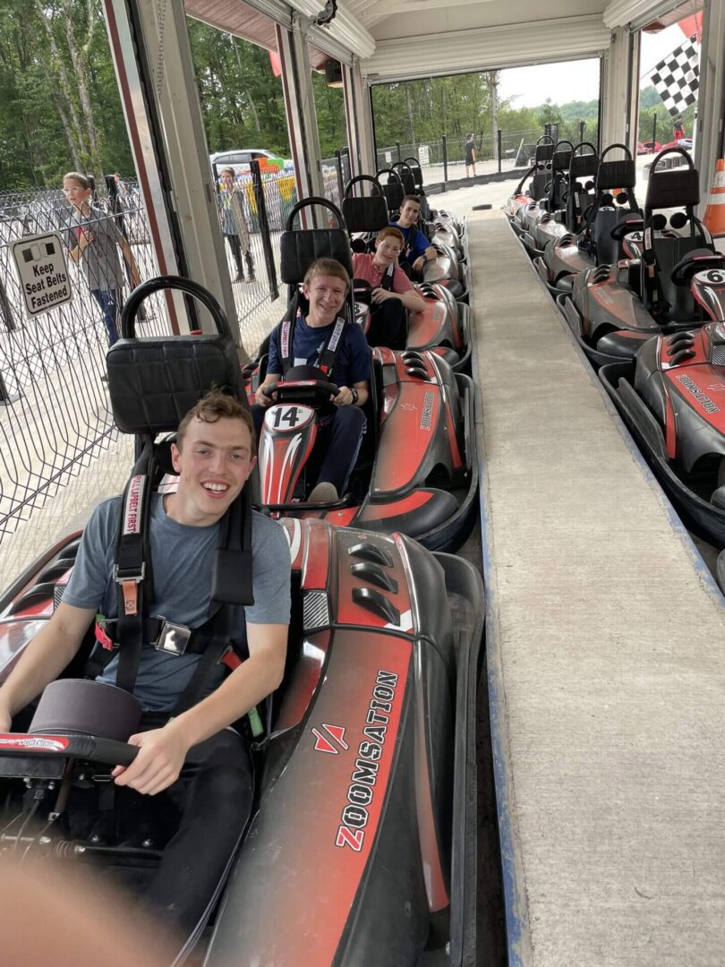 A group of young people riding on the side of a track.