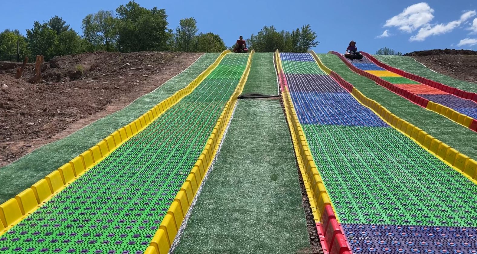 A slope with colored plastic mats and grass.